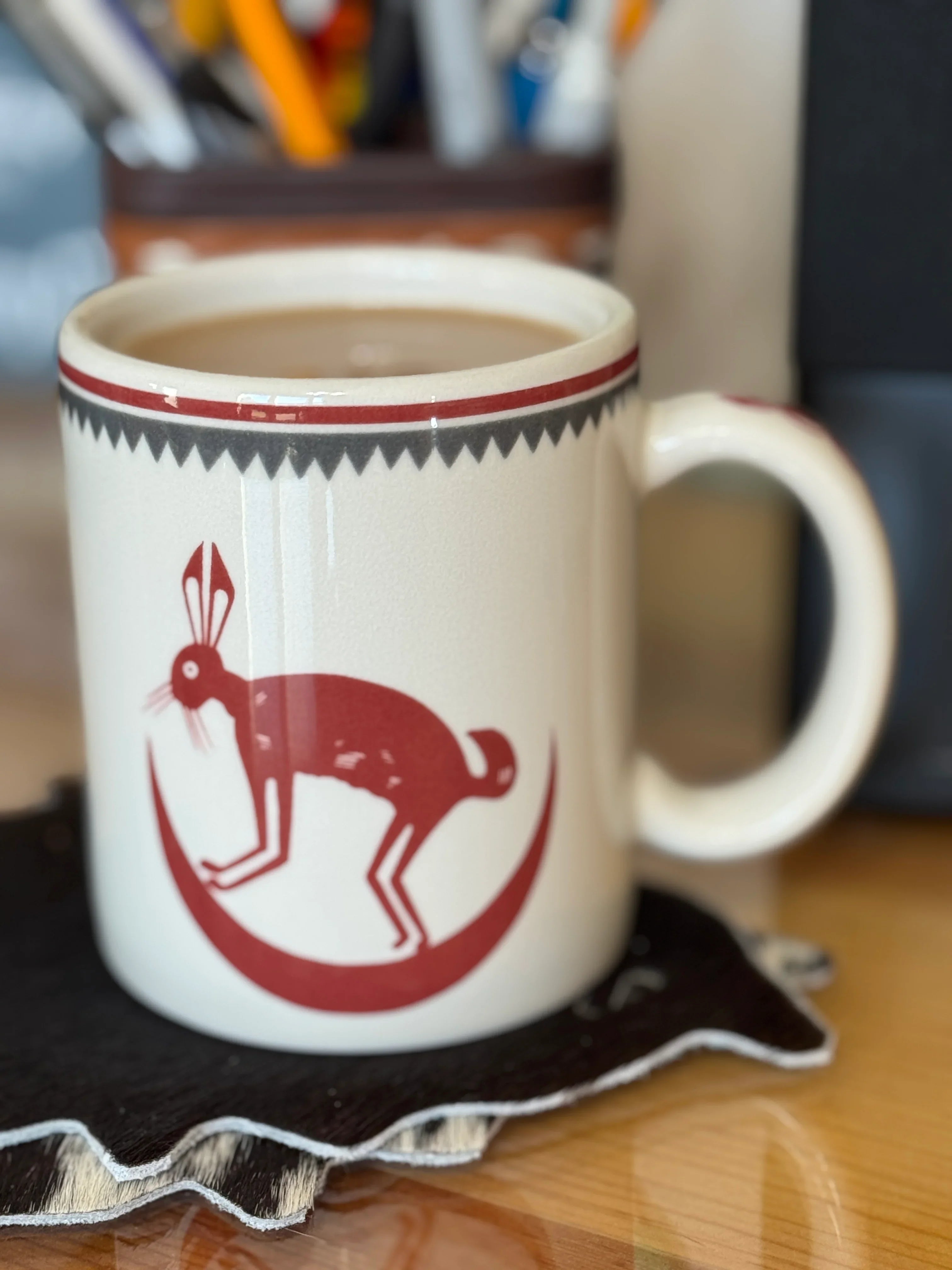 Mug with a red rabbit design on a coaster, filled with a beverage - Blue Mountain Brands USA