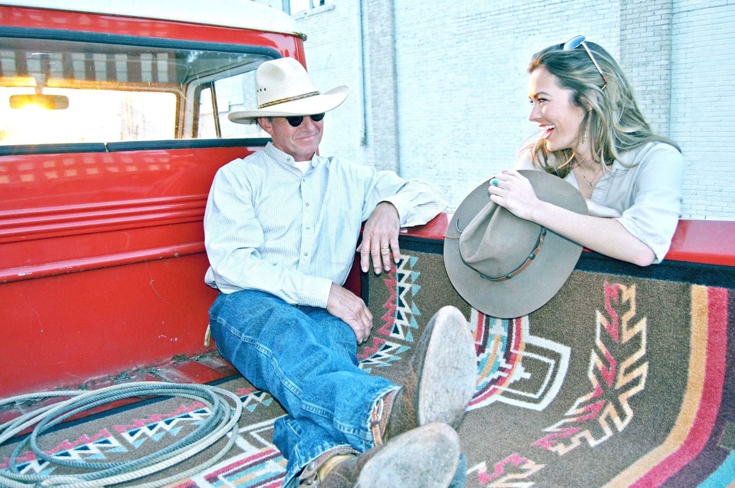 Sunset canyon cross rug in back of pickup with man and lady talking