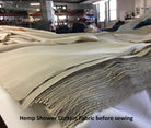 Stack of hemp shower curtain fabric before sewing in a warehouse setting