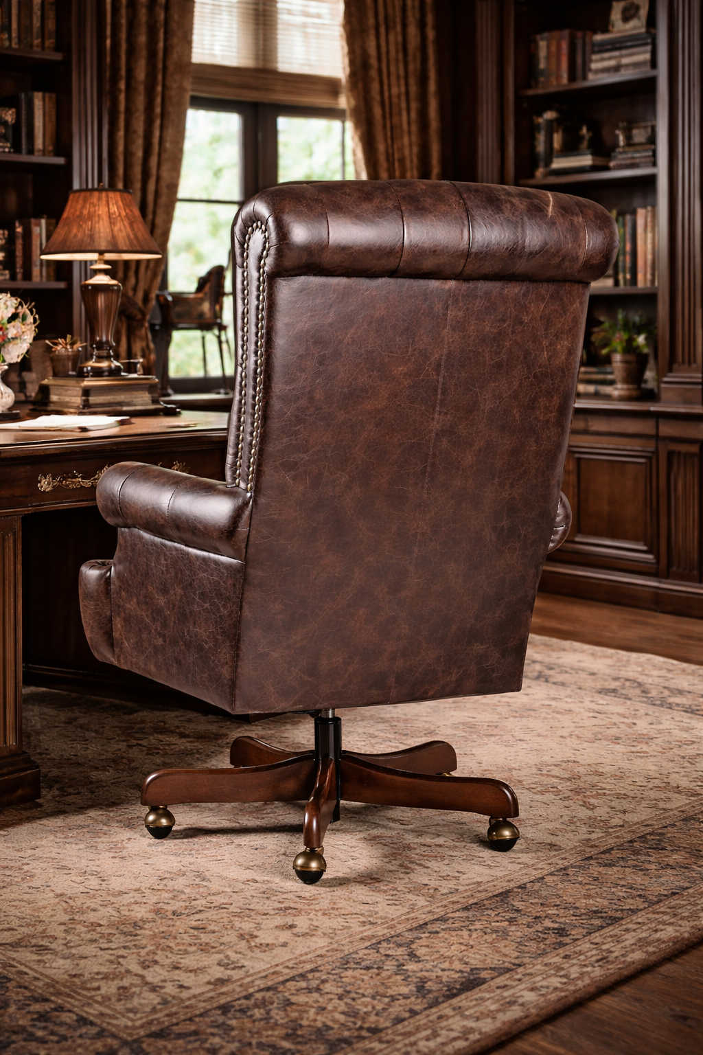 Back view of Prescott tufted brown leather office chair in a room with bookshelves and a desk.