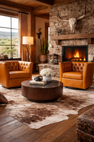 Cozy living room with stone fireplace, leather chairs, and a cow skull decor - Blue Mountain Brands USA