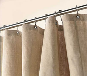 Beige curtains hanging on a rod against a beige wall