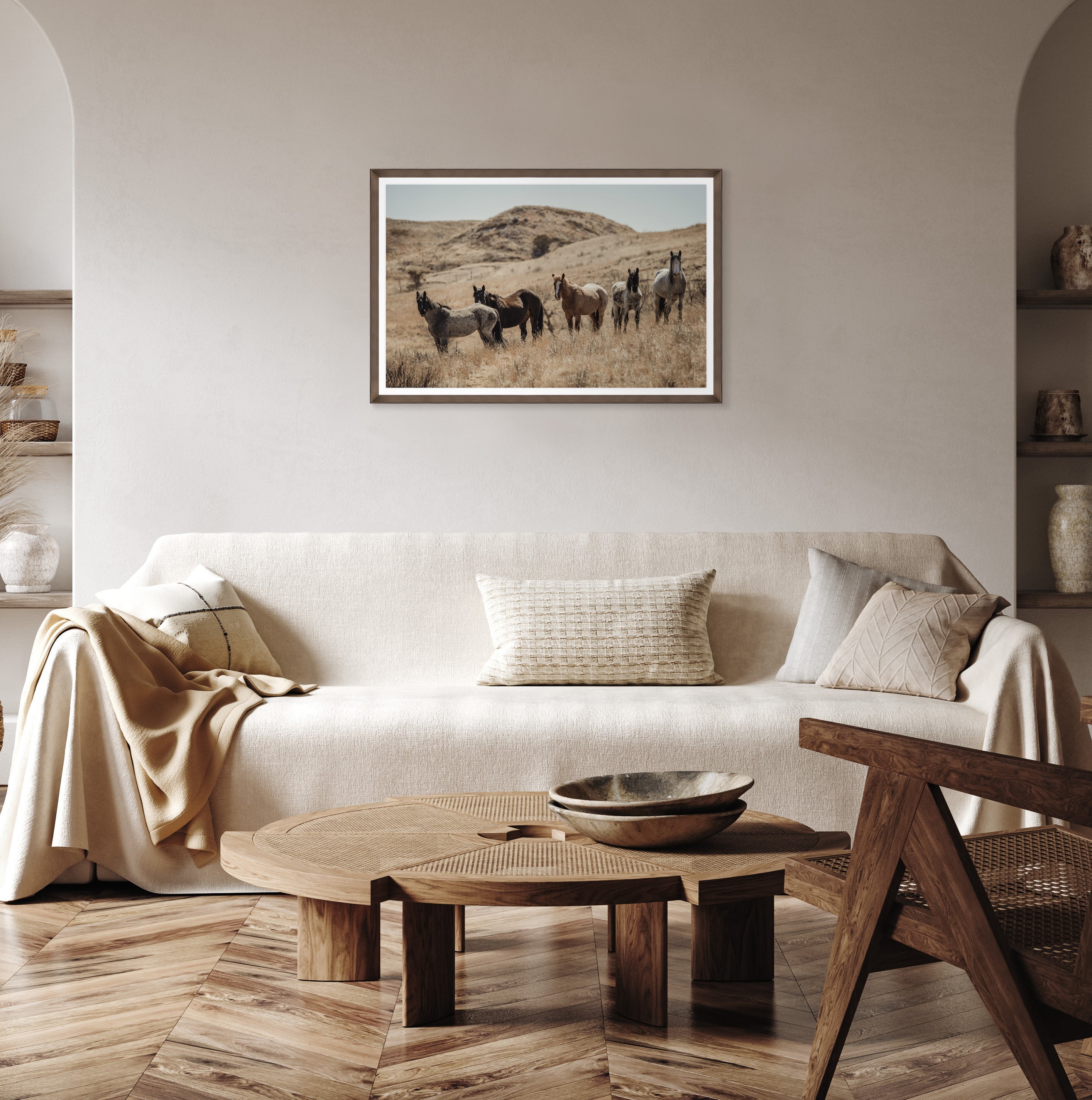 Living room with a beige sofa, wooden coffee table, and framed picture of horses on the wall - Blue Mountain Brands USA