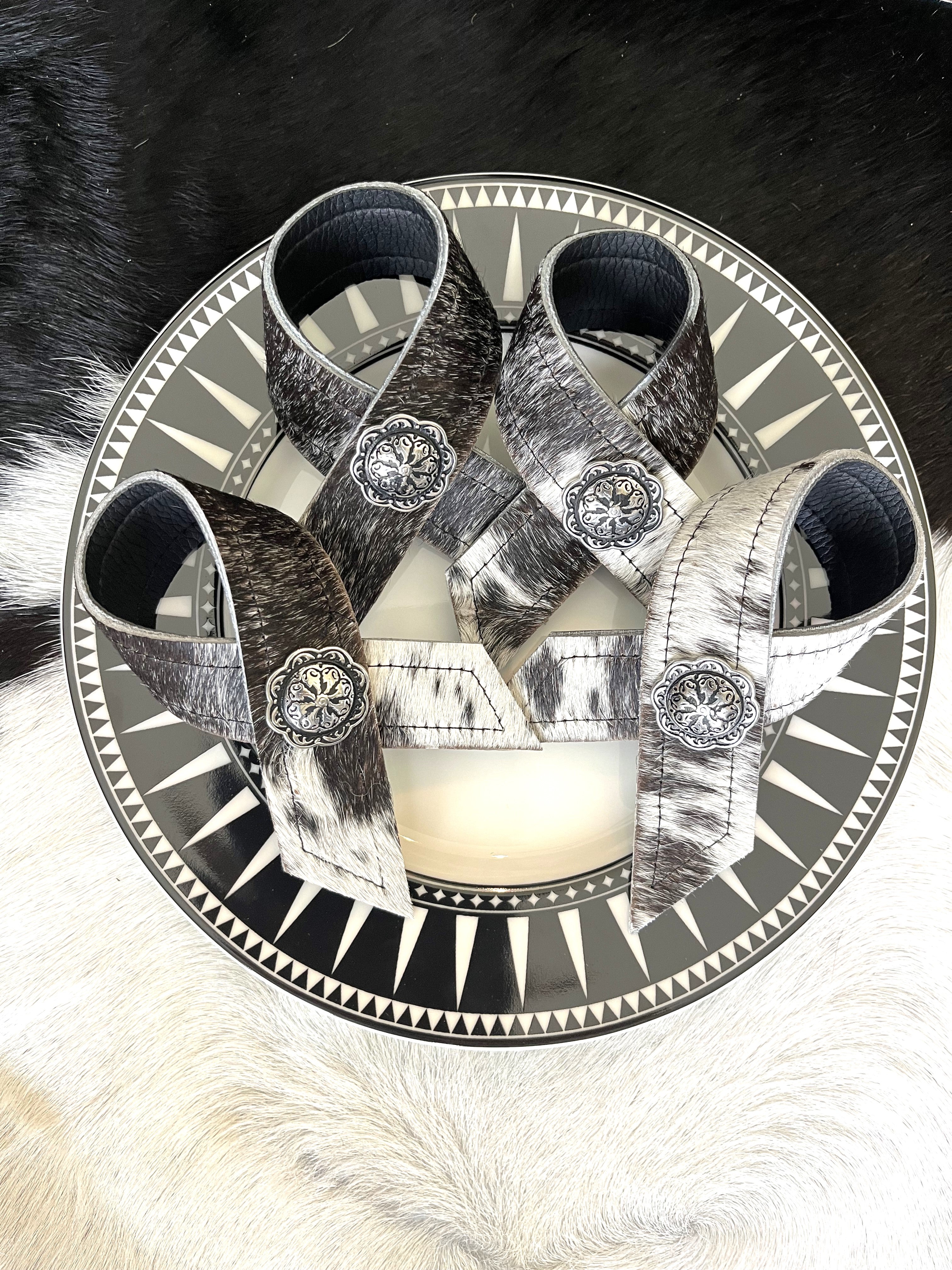 Cowhide napkin rings on black burst salad plate - Blue Mountain Brands USA Home Decor